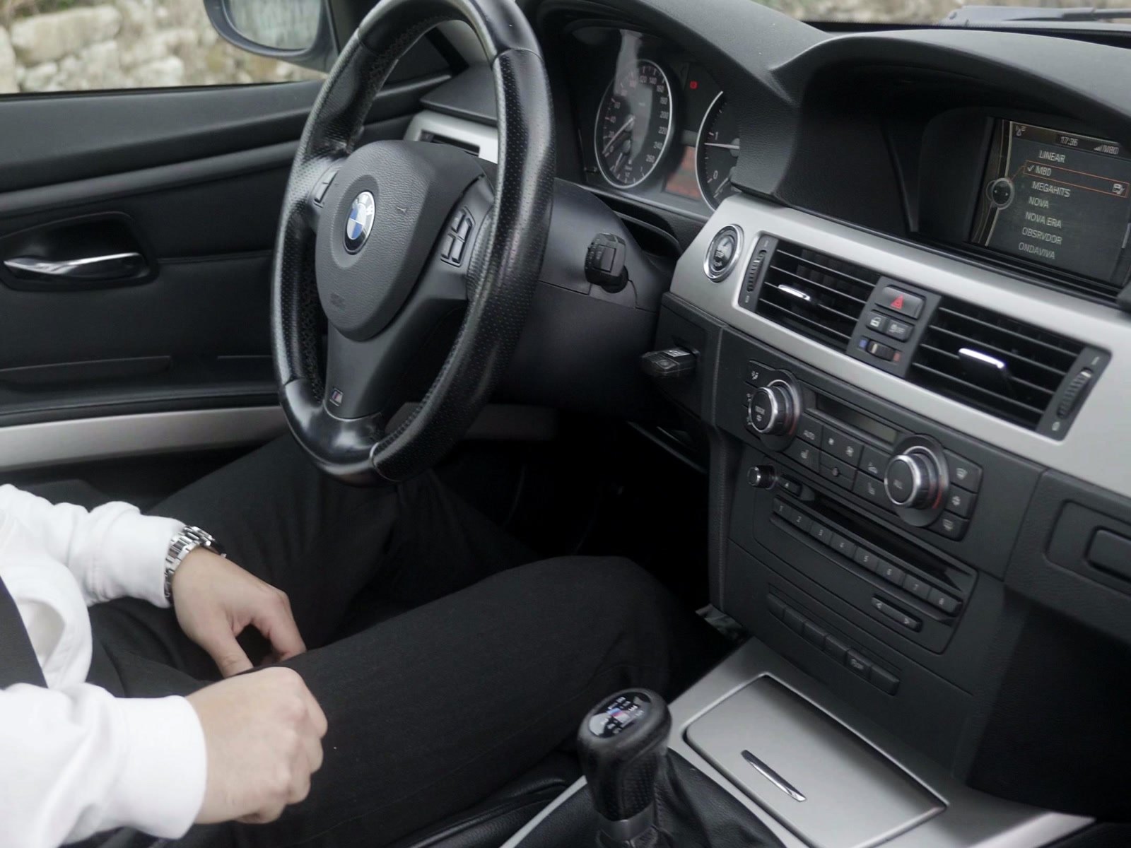 Interior do BMW E92 com volante, consola virada para o condutor e caixa manual